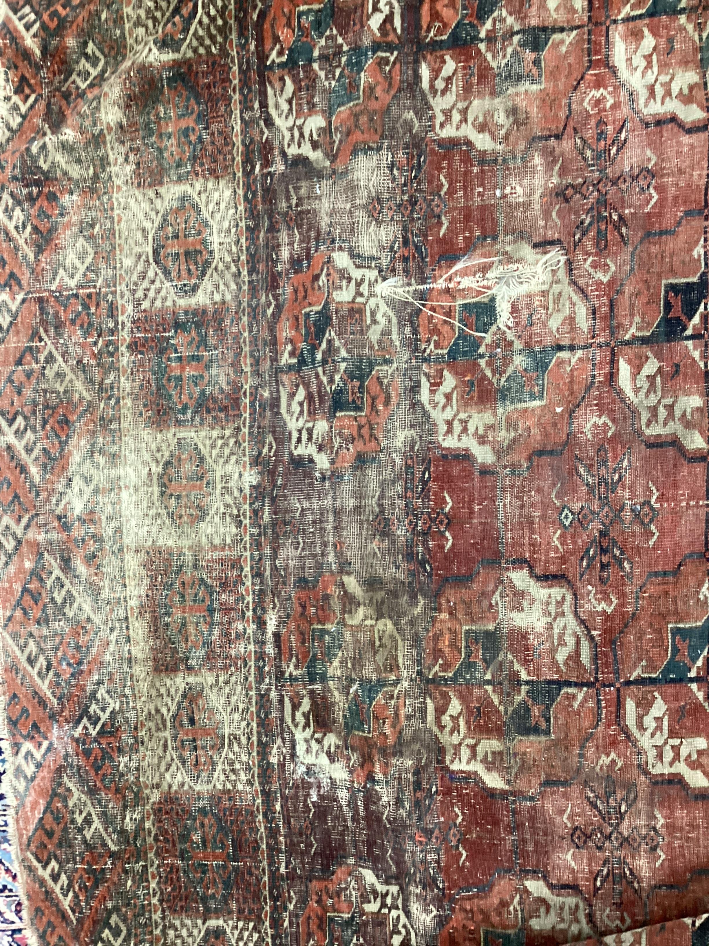 An antique Tekke Turkoman carpet, 290 x 214cm (cut and severely worn) and a similar smaller rug